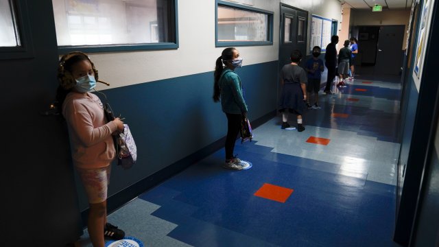 Los Angeles Unified School District students stand in a hallway socially distance during a lunch break.