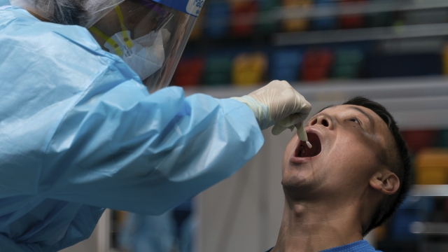 Swab sample is collected from a man at a makeshift testing site in Hong Kong