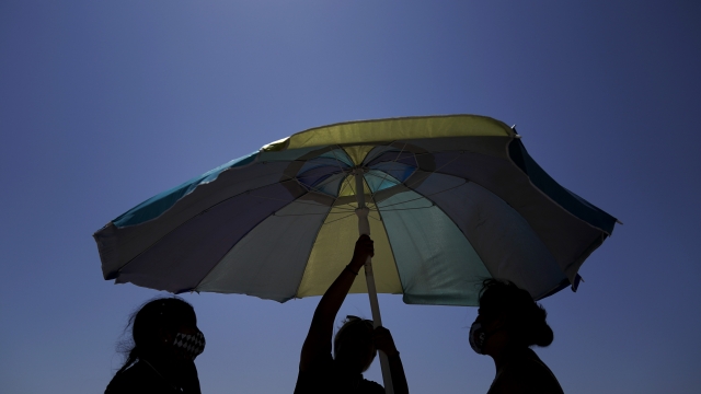 Beach goers set up an umbrella