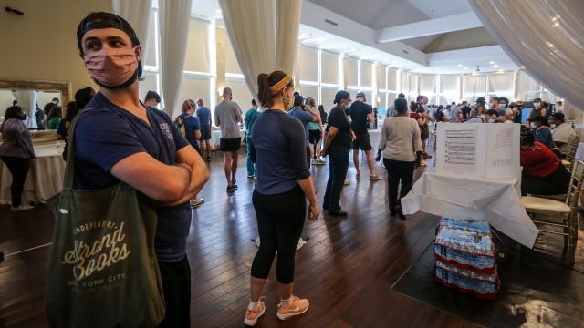 Voters wait in line to cast their ballots in the state's primary election at a polling place, Tuesday, June 9, 2020