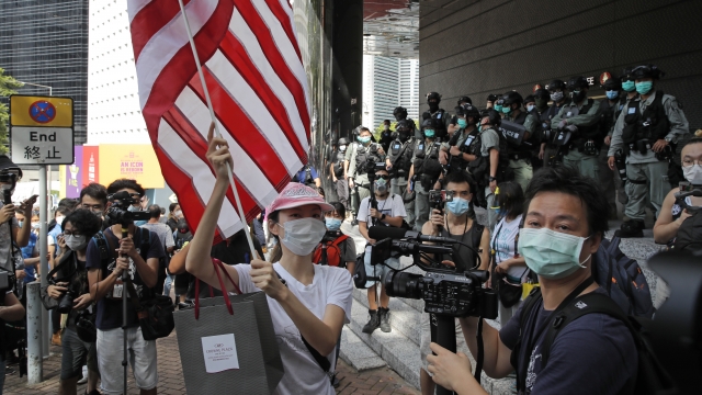 A woman carries an American flag during a protest outside the U.S. Consulate in Hong Kong.