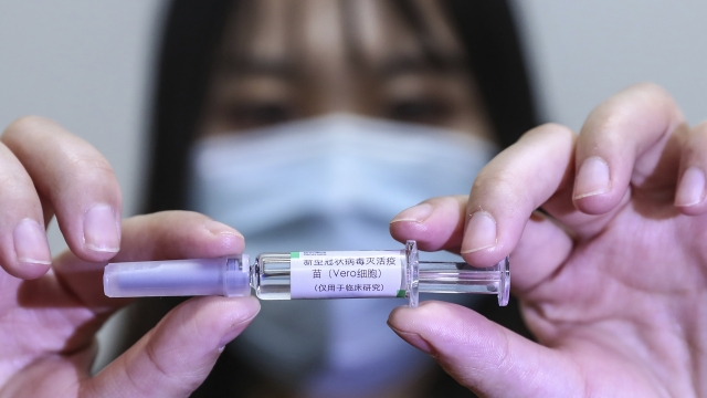 A staff member holds up a sample of a potential COVID-19 vaccine.