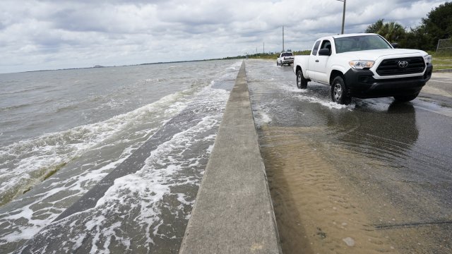 Waters from the Gulf of Mexico pour onto a local road.