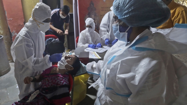 Health workers collect a swab sample to test for COVID-19 in Mumbai, India, Wednesday, Sept. 16, 2020