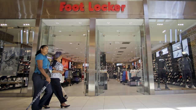Shoppers walk past a Foot Locker store in Hialeah, Fla.