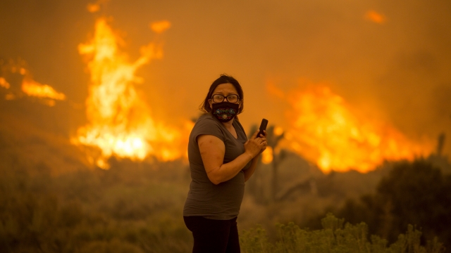 A woman watches as the Bobcat Fire burns in Juniper Hill, Calif.
