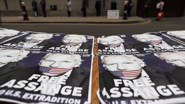 People queue at the entrance of the Old Bailey court in London, Monday, Sept. 21, 2020, as the Julian Assange extradition hea