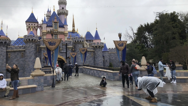Visitors take photos at Disneyland in Anaheim, CA on March 13, 2020