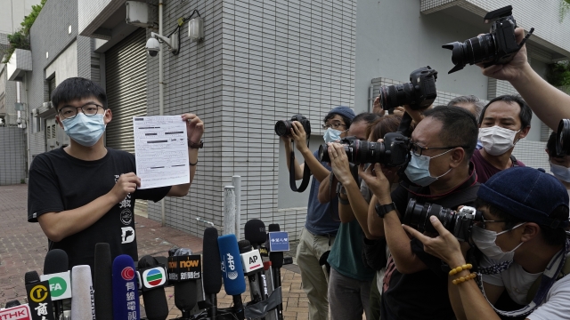 Hong Kong pro-democracy activist Joshua Wong displays a bail paper outside the Central Police Station in Hong Kong.
