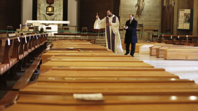 Italian priest blesses coffins