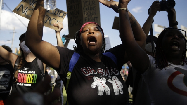 A protester marches Saturday, June 13, 2020, near the Atlanta Wendy's where Rayshard Brooks was shot and killed.