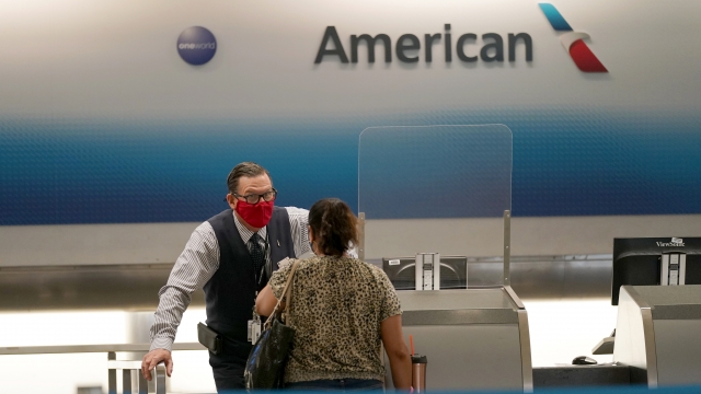 An American Airlines ticket agent works with a customer at Miami International Airport