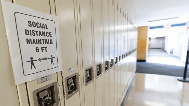 Sign reads "Social Distance Maintain 6 ft" on student lockers at a school
