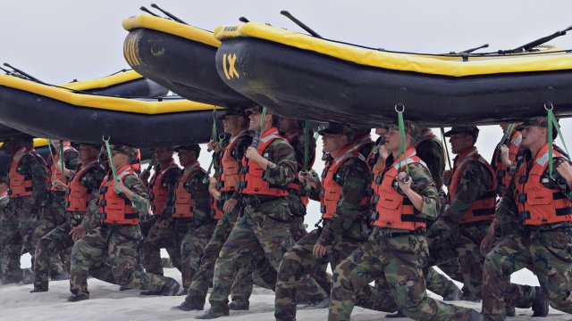 Navy SEAL trainees carry inflatable boats at the Naval Amphibious Base Coronado in Coronado, Calif.