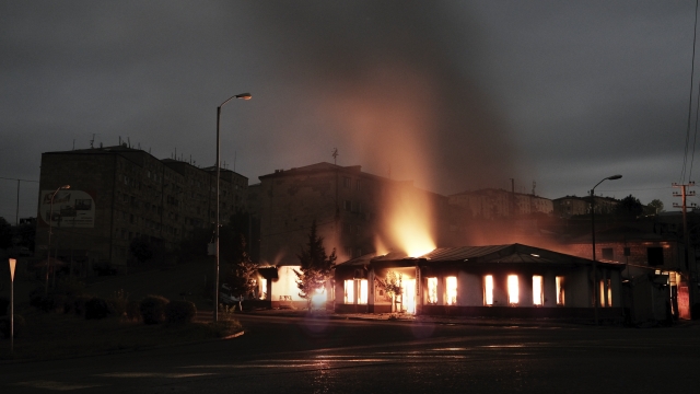 A building of a residential area burns after night shelling by Azerbaijan's artillery during a military conflict