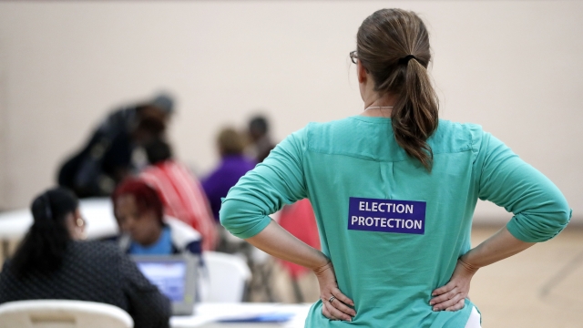 A poll watcher watches as voters sign in at a polling site in Tennessee.