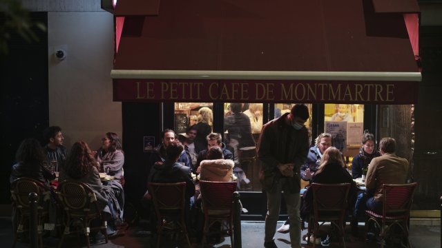 people enjoy a drink in a cafe terrace in Paris.