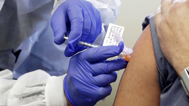 A volunteer receives a shot in the first-stage safety study clinical trial of a potential vaccine for COVID-19.