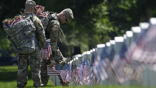 Members of the 3d U.S. Infantry Regiment place flags... at Arlington National Cemetery in Arlington.