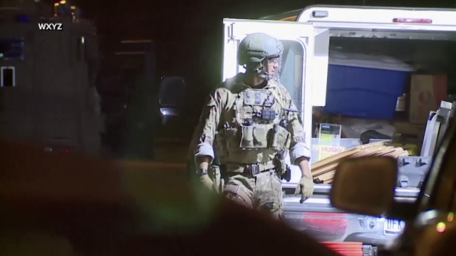 Officer in camouflage as FBI and police raid Hartland, Michigan home investigating kidnap plot against governor.