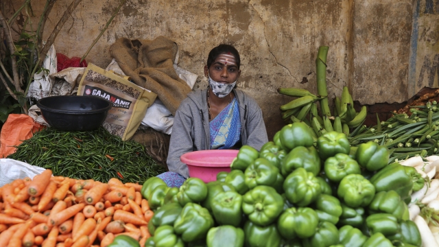 Indian shopkeeper waits for customers wearing a mask