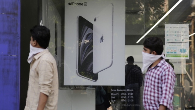 People walk past an image of an iPhone displayed at an Apple store in Ahmedabad, India.