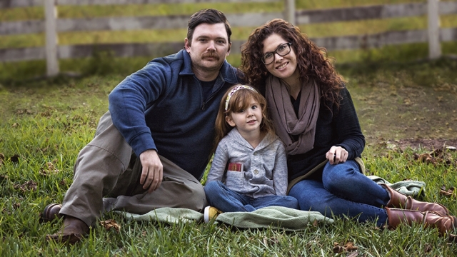 Military caregiver Shaina Purser poses with her husband, a military veteran, and daughter