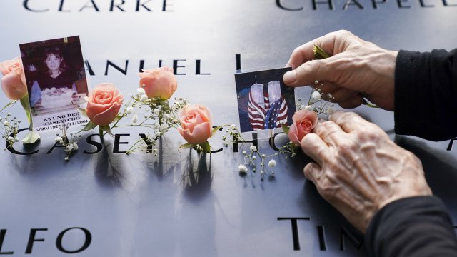 Mourners place flowers and pictures at the National September 11 Memorial and Museum.