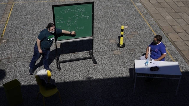A teacher leads a lesson outdoors at the school Hipólito Yrigoyen in Buenos Aires, Argentina.