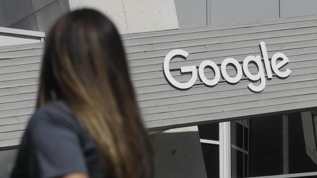 A woman walks by the Google sign on it's campus in Mountain View, California.
