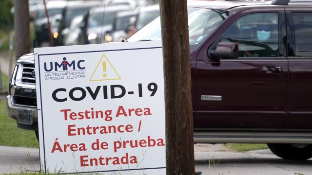 People wait inside their vehicles in line at a COVID-19 testing site