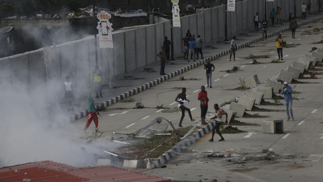 Protesters run away as police officers use teargas to disperse people demonstrating against police brutality in Nigeria.