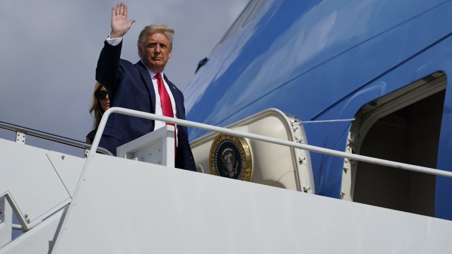 President Donald Trump waves as he and first lady Melania Trump board Air Force One to travel to Nashville, Tenn.,