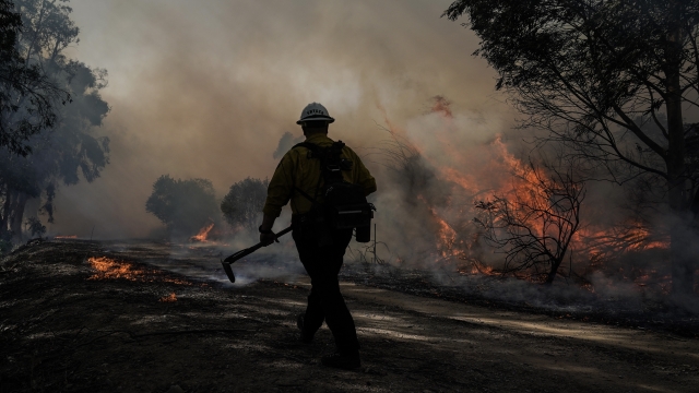 A firefighter prepares to put out hotspots while battling the Silverado Fire in California