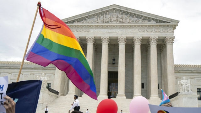 FILE: Supporters of the LGBT wave their flag in front of the U.S. Supreme Court, Tuesday, Oct. 8, 2019.
