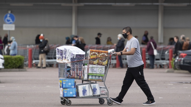 One shopper walks away with a full cart as others queue outside a major supermarket in Leicester, England, Sunday Nov. 1