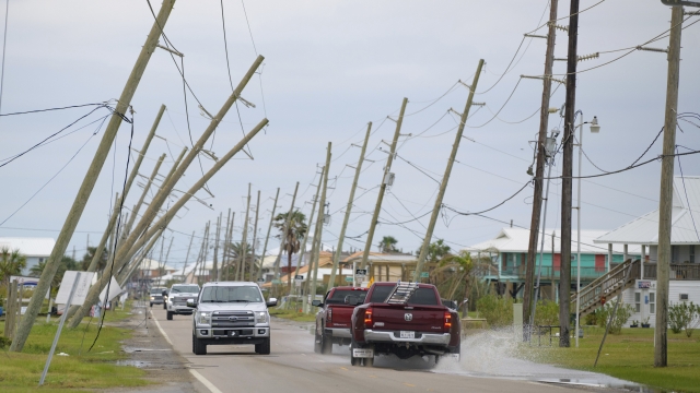 Cars drive near fallen power lines in Louisiana
