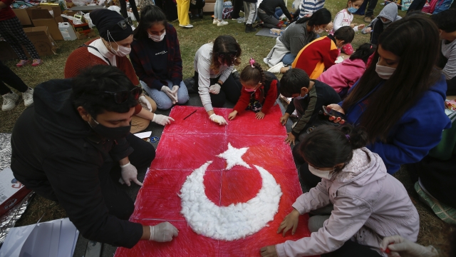 Turkish citizens gather outside around flag