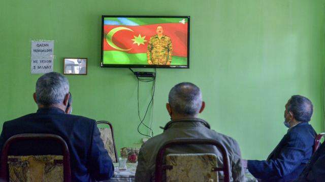 People listen to Azerbaijan's President Ilham Aliyev speaking on television live at a teahouse in Barda, Azerbaijan Sunday