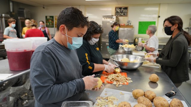 Volunteers peel potatoes and prepare other Thanksgiving food for seniors