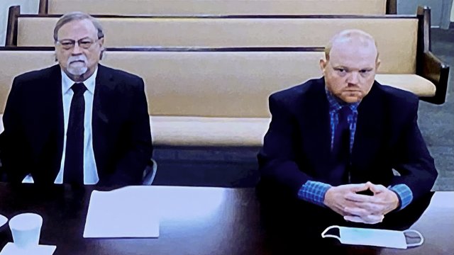 In this image made from video, from left, father and son, Gregory and Travis McMichael, accused in the shooting death of Ahma