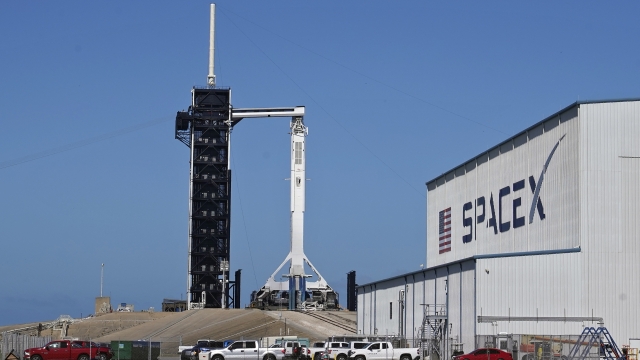 A SpaceX Falcon 9 rocket, with the company's Crew Dragon capsule attached, sits on the launch pad.