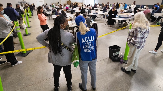 Democrat observers confer as they look on during a Cobb County hand recount of Presidential votes on Sunday, Nov. 15, 2020, i