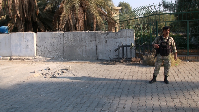 An army soldier inspects the scene of the rocket attack at the gate of al-Zawra public park in Baghdad, Iraq
