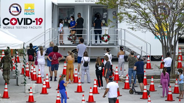people stand in line to being tested at the COVID-19 mobile testing facility at Miami Beach