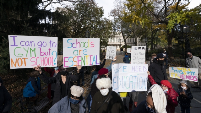 Parents and children gather in front of New York's City Hall to protest the closing of public schools.