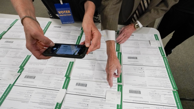 A canvas observer photographs provisional ballots as vote counting in Allentown, Pennsylvania