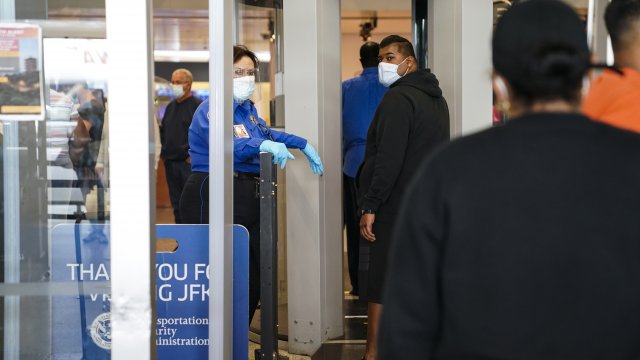 A TSA employee checks passengers at John F. Kennedy International Airport.