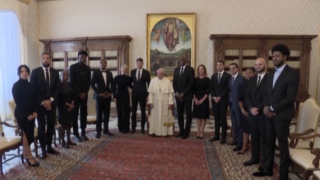 Pope Francis poses for a photo with NBA players at the Vatican.