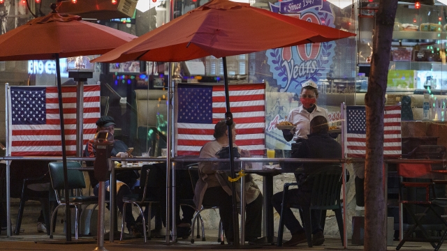 Patrons sits outdoors for dinner separated by plastic dividers in Los Angeles, California